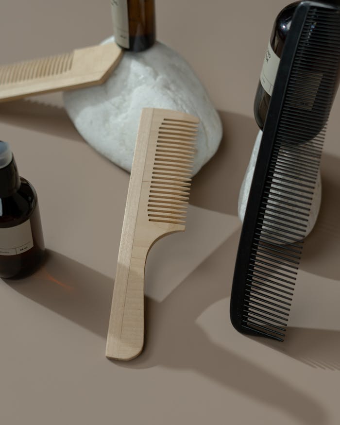 about-01 Minimalist display of wooden and plastic hair combs on stones with amber bottles, ideal for beauty product ads.